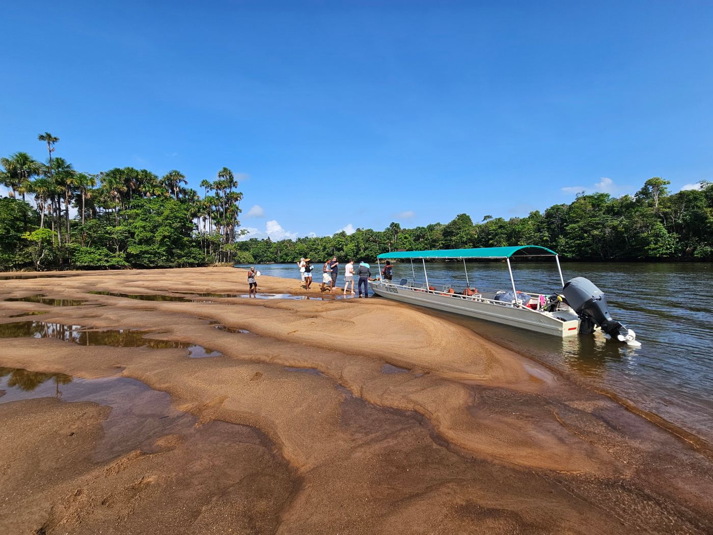 Passagers sur un banc de sable de la Comté, à côté du bateau